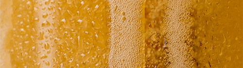 Gros plan sur la mousse d’une bière sans alcool bien fraîche – texture onctueuse et effervescence dorée