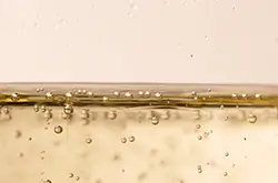 Gros plan sur un verre de vin pétillant sans alcool – bulles fines et robe brillante